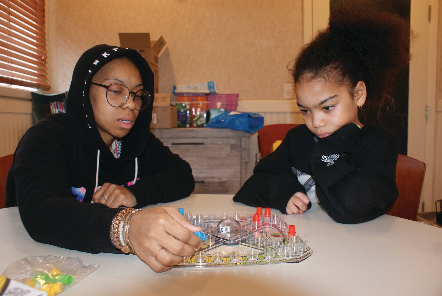 A ROUND OF TROUBLE: Whitney Wilborn and Jeena Lim, 8, enjoy a mother-daughter day out. The two eyed the game Trouble at the Huddle Center and just had to play.